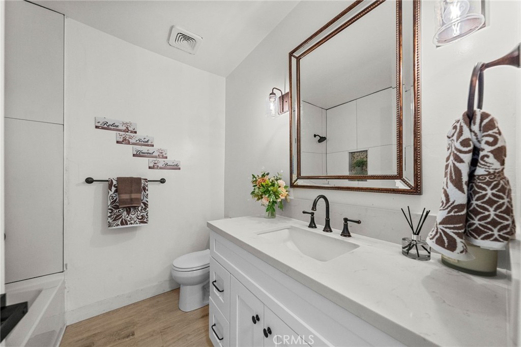 4881 Arlington Avenue Riverside, CA 92504 - Photo 22 of 37 a bathroom with a toilet sink and mirror
