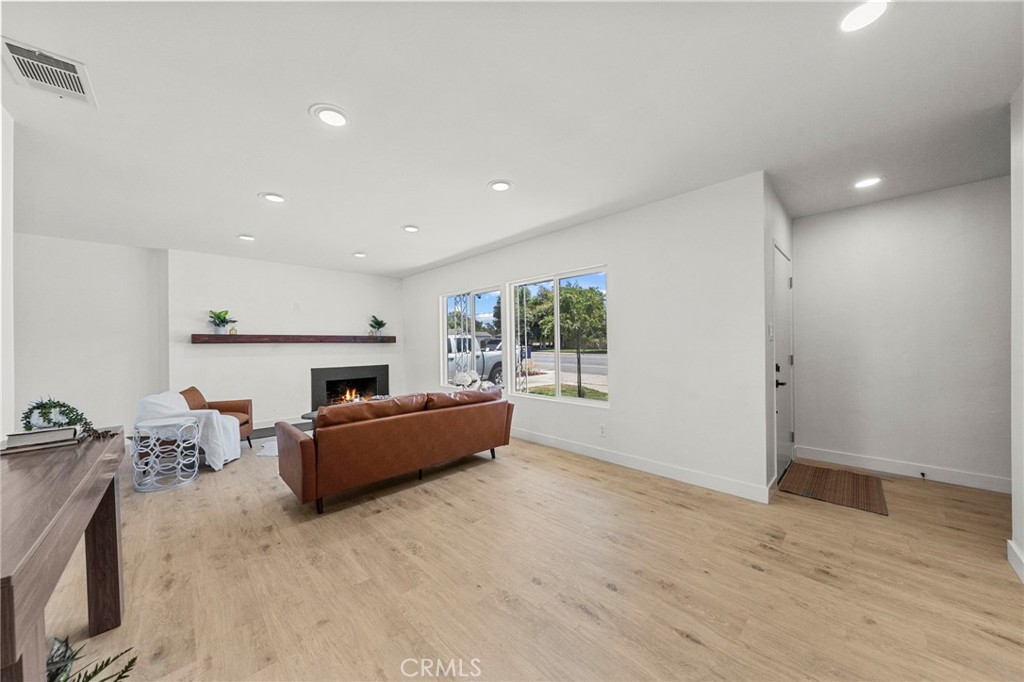 4881 Arlington Avenue Riverside, CA 92504 - Photo 7 of 37 a living room with furniture a fireplace and a wooden floor