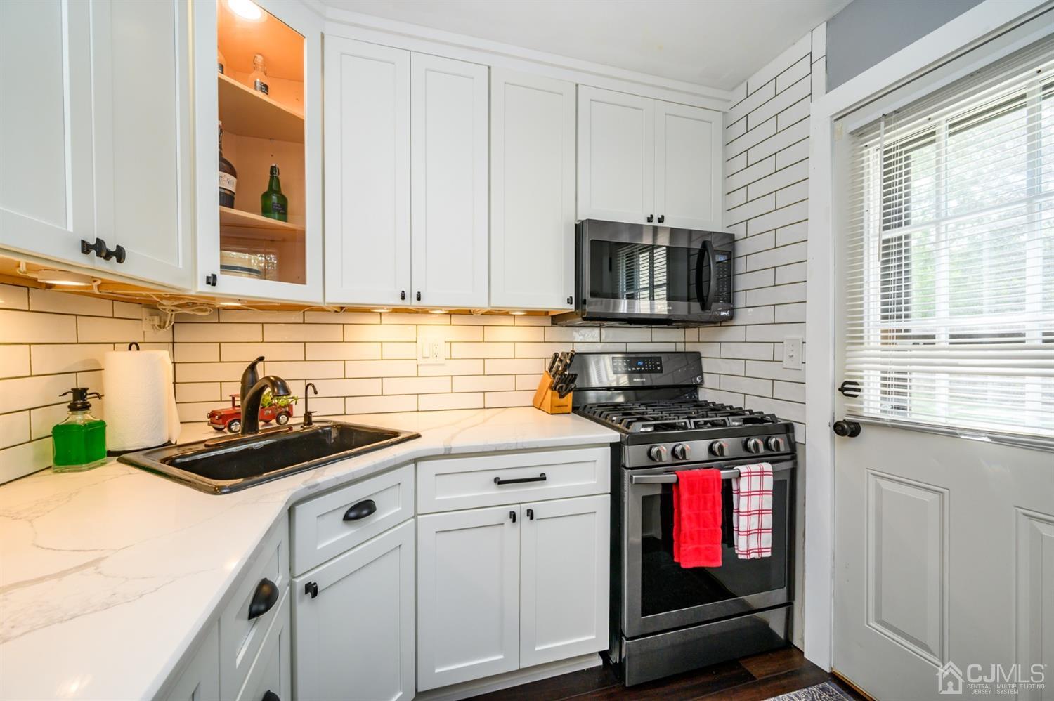 420 Cross Road, Unit B3 Matawan, NJ 07747 - Photo 13 of 24 a kitchen with stainless steel appliances a stove a sink a microwave and cabinets