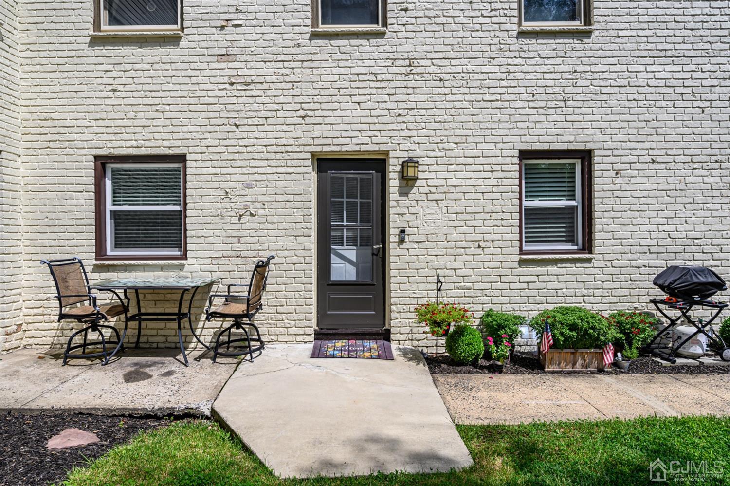420 Cross Road, Unit B3 Matawan, NJ 07747 - Photo 19 of 24 a brick house with table and chairs in front of it