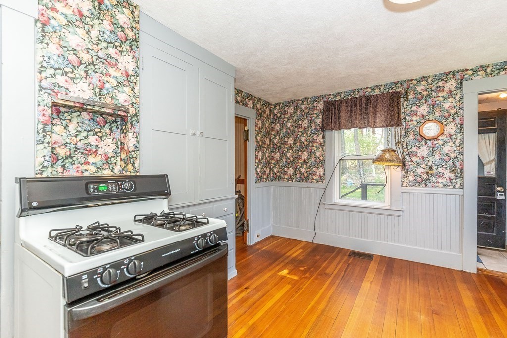 600 Springs Road Bedford, MA 01730 - Photo 12 of 38 a kitchen that has a stove and a wooden floor