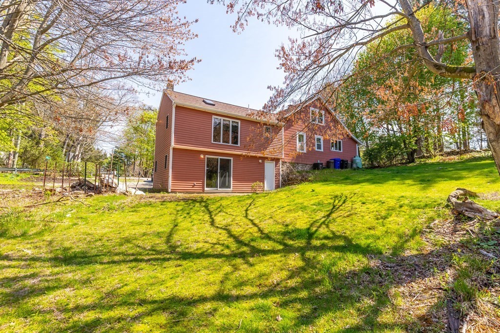 600 Springs Road Bedford, MA 01730 - Photo 4 of 38 a brick house with a big yard plants and large trees