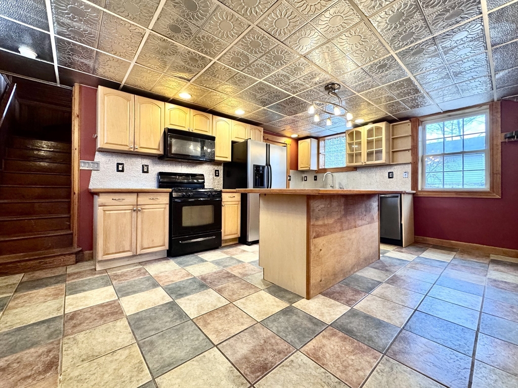 53 Circuit Road Dedham, MA 02026 - Photo 15 of 26 a open kitchen with stainless steel appliances granite countertop a stove a sink dishwasher and granite countertops