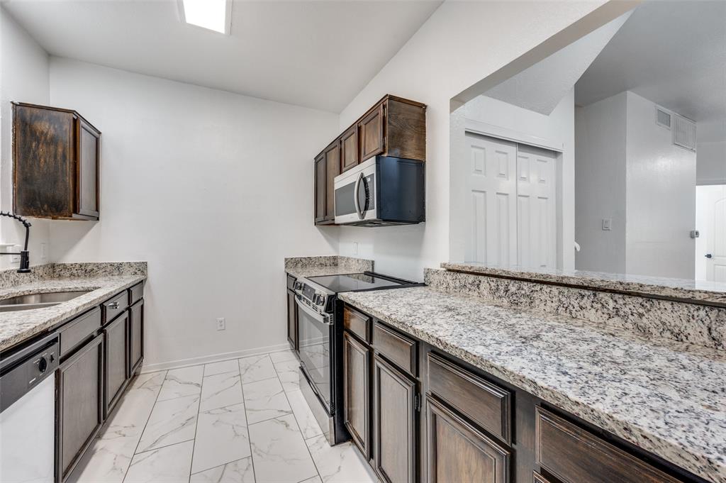 5550 Spring Valley Road, Unit E22 Dallas, TX 75254 - Photo 9 of 14 a kitchen with granite countertop a sink and a stove top oven