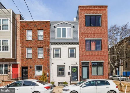 a front view of a building with lot of cars parked