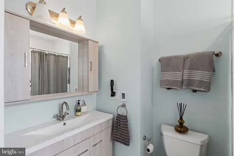 a bathroom with a sink a toilet and mirror