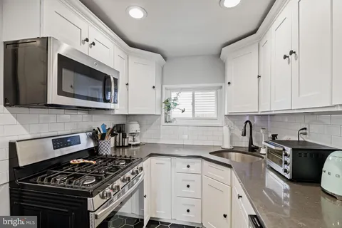 a kitchen with stainless steel appliances a stove a sink a stove and cabinets