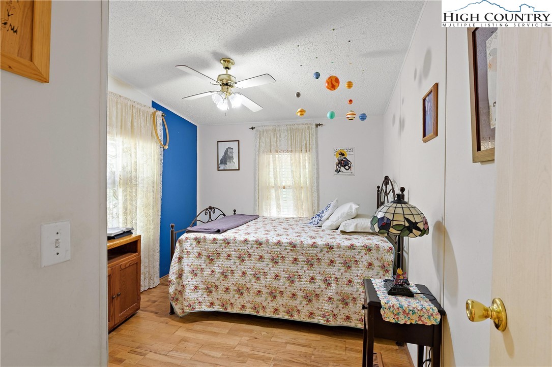 787 Lawrence Greene Road Deep Gap, NC 28618 - Photo 21 of 45 a bedroom with a bed and a chandelier