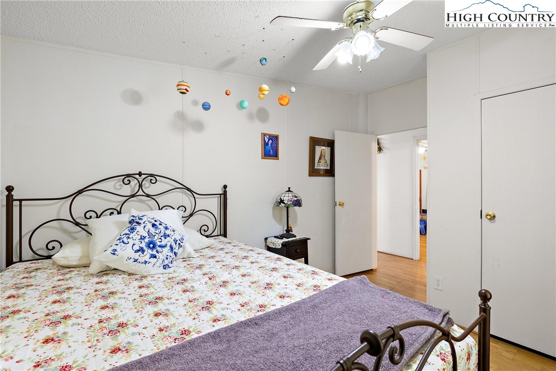 787 Lawrence Greene Road Deep Gap, NC 28618 - Photo 22 of 45 a bedroom with a bed and a chandelier