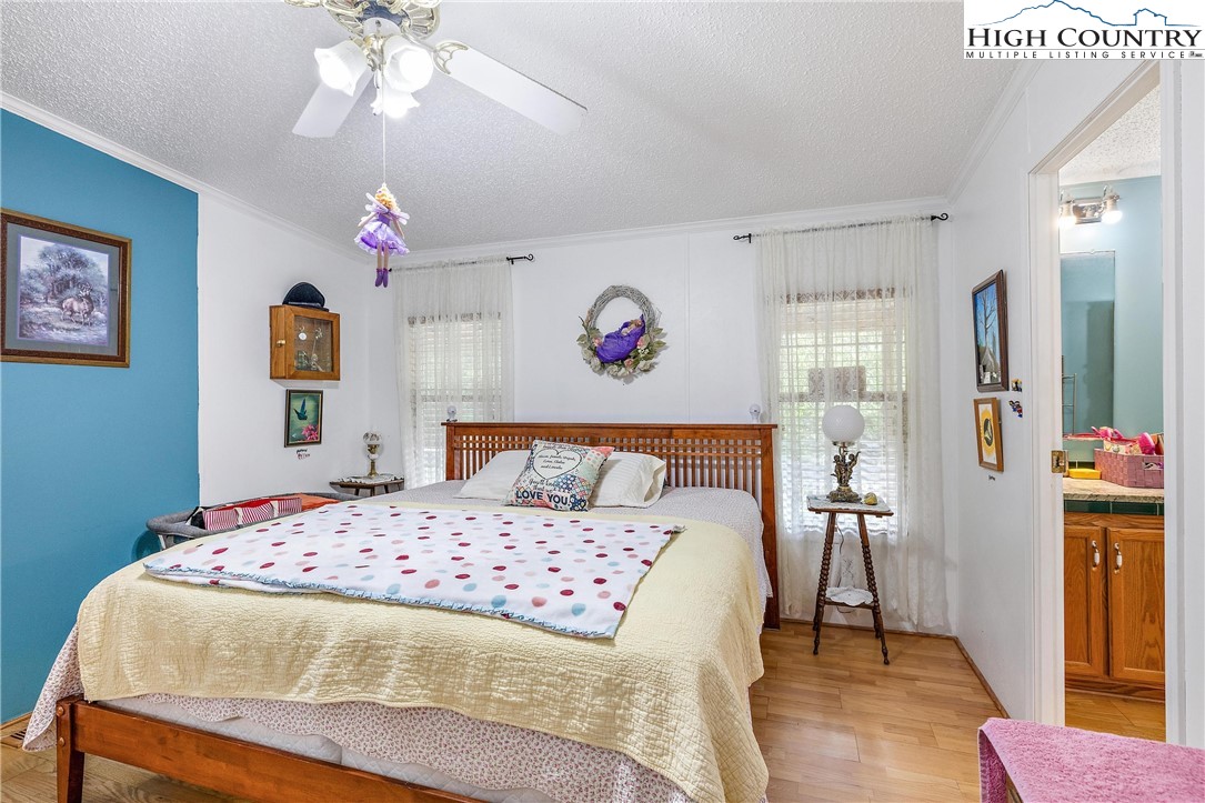787 Lawrence Greene Road Deep Gap, NC 28618 - Photo 24 of 45 a bedroom with a bed and a chandelier