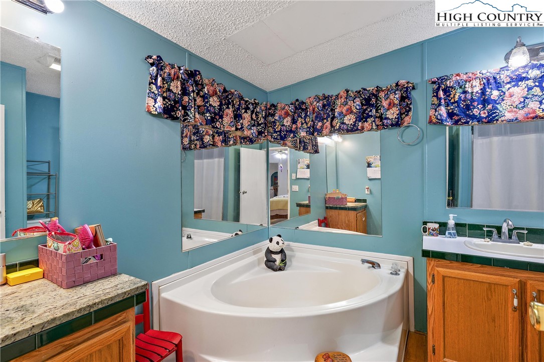 787 Lawrence Greene Road Deep Gap, NC 28618 - Photo 26 of 45 a bathroom with a sink mirror and vanity