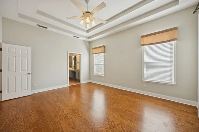 a view of an empty room with a window and wooden floor