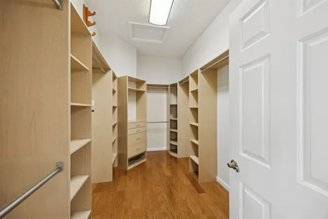 a view of walk in closet with wooden floor