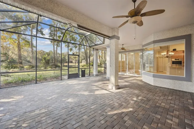 a view of an empty room with wooden floor and windows