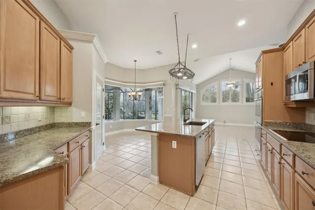 a kitchen with stainless steel appliances granite countertop a sink and a stove