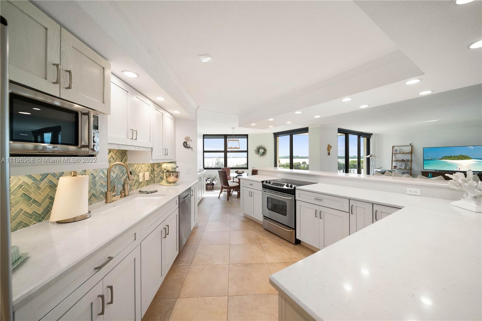 a large white kitchen with stainless steel appliances