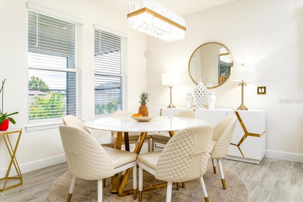 1296 Waterview Ridge Circle Apopka, FL 32703 - Photo 23 of 60 a dining room with wooden floor a glass table and chairs