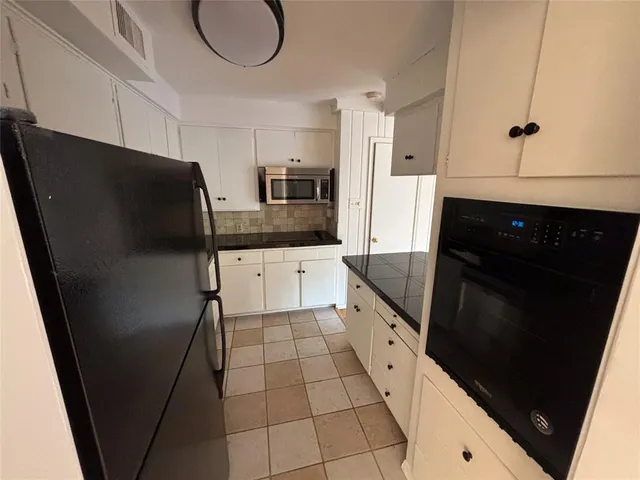 a kitchen with stainless steel appliances a refrigerator a sink a stove and cabinets