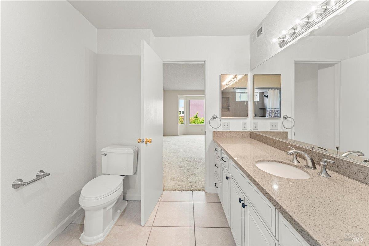 2121 Vale Road, Unit 31 San Pablo, CA 94806 - Photo 23 of 36 a spacious bathroom with a granite countertop sink a toilet and a mirror