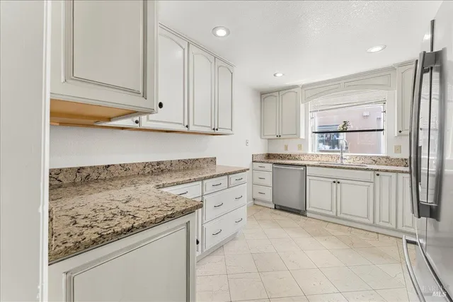 a kitchen with granite countertop cabinets and white appliances