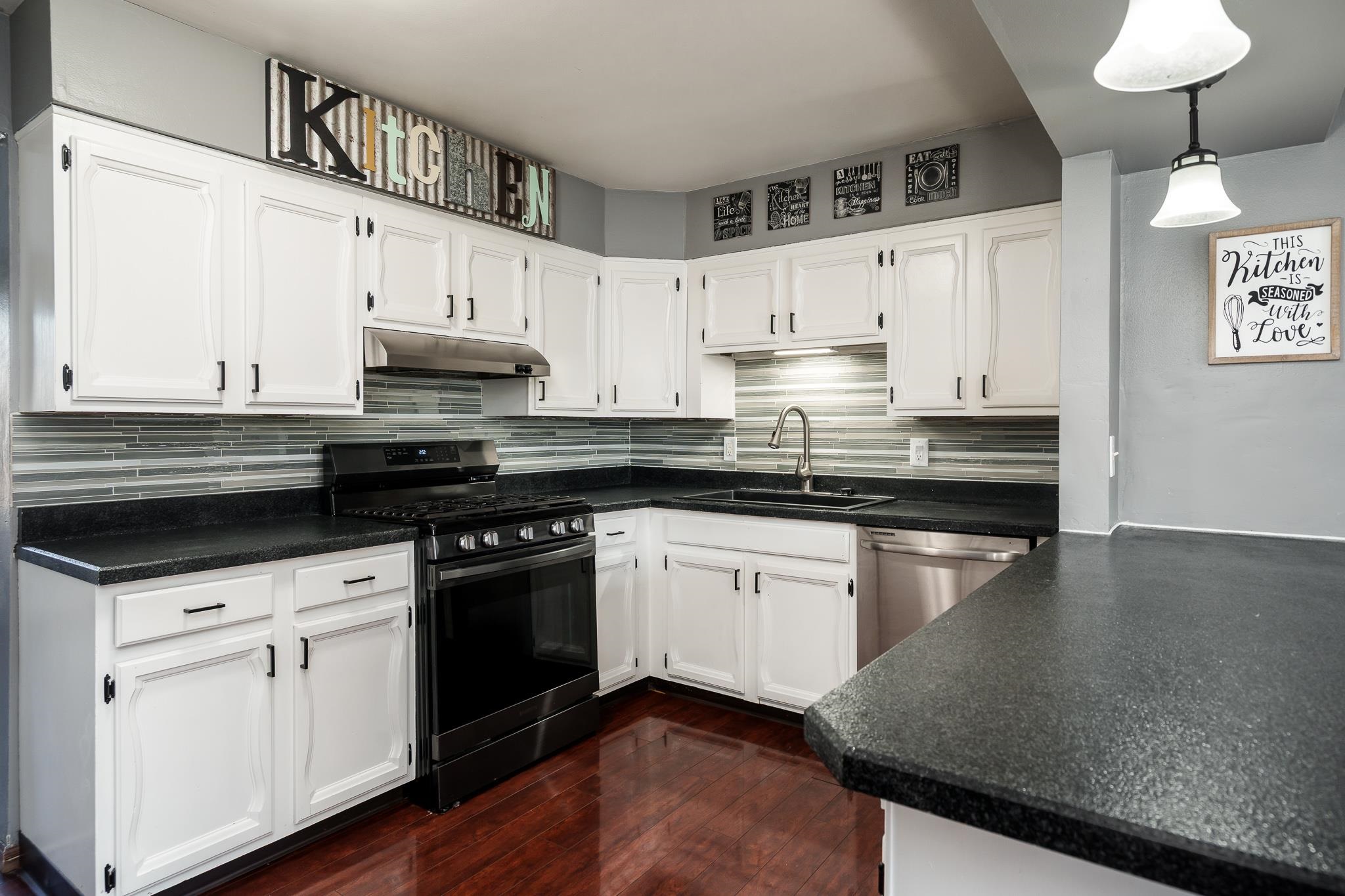 237 Theodore Street Loves Park, IL 61111 - Photo 11 of 33 a kitchen with stainless steel appliances granite countertop a sink a stove and white cabinets