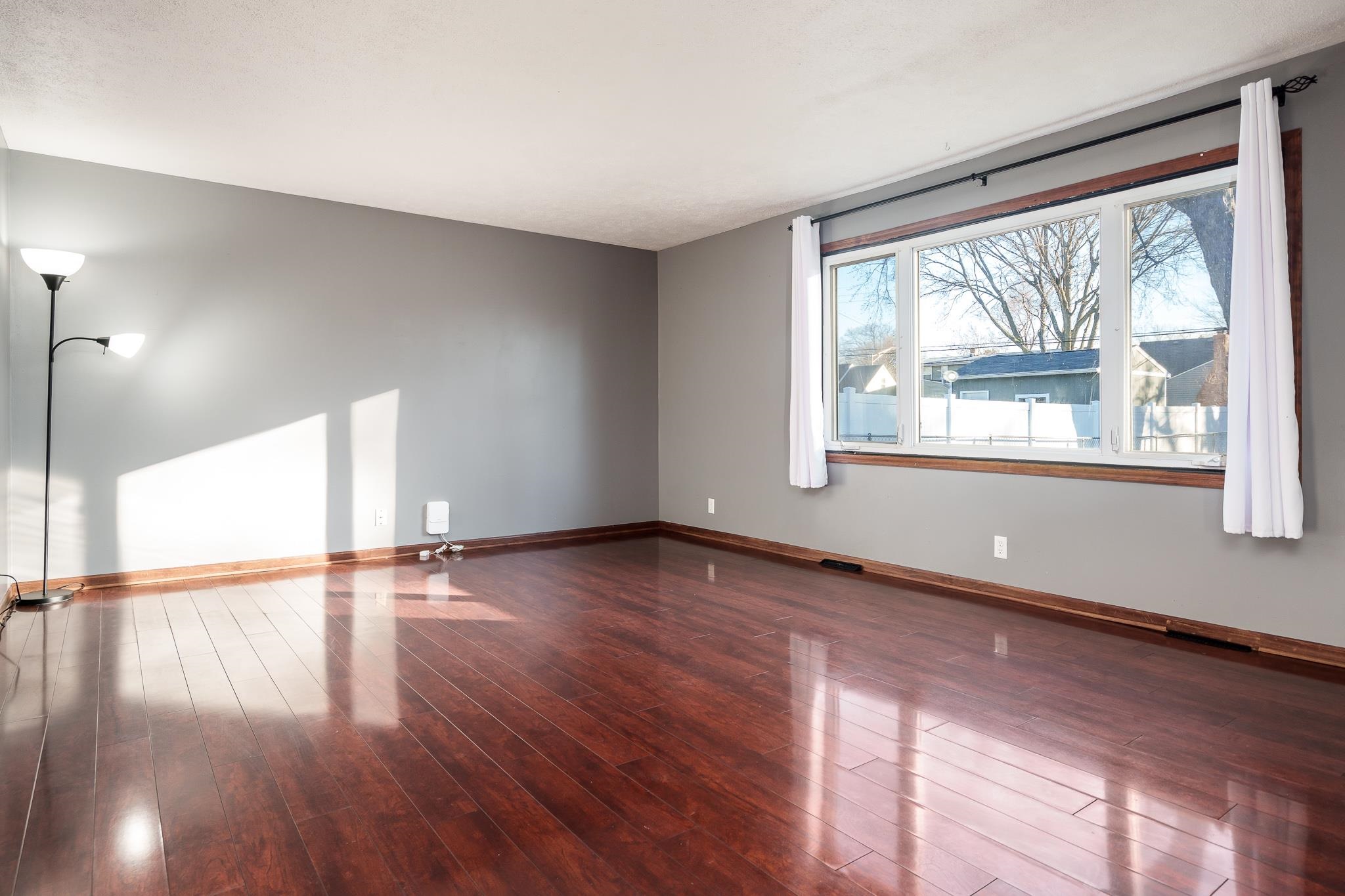 237 Theodore Street Loves Park, IL 61111 - Photo 21 of 33 a view of an empty room with wooden floor and a window