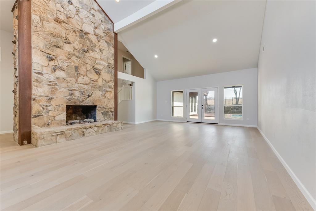 an empty room with windows and fireplace