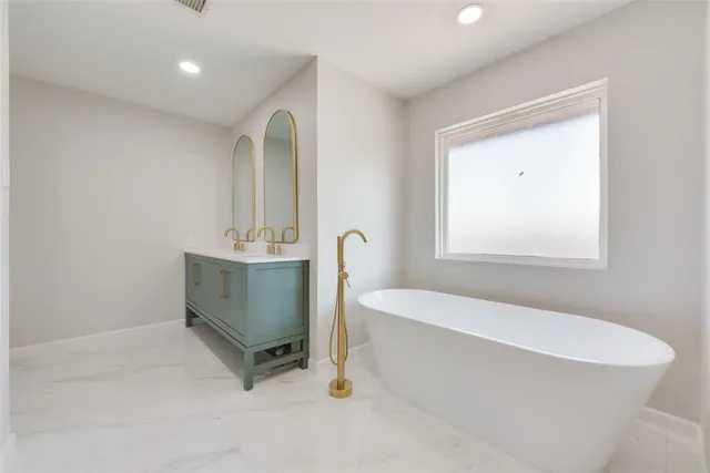 a bathroom with a sink a bathtub and a window