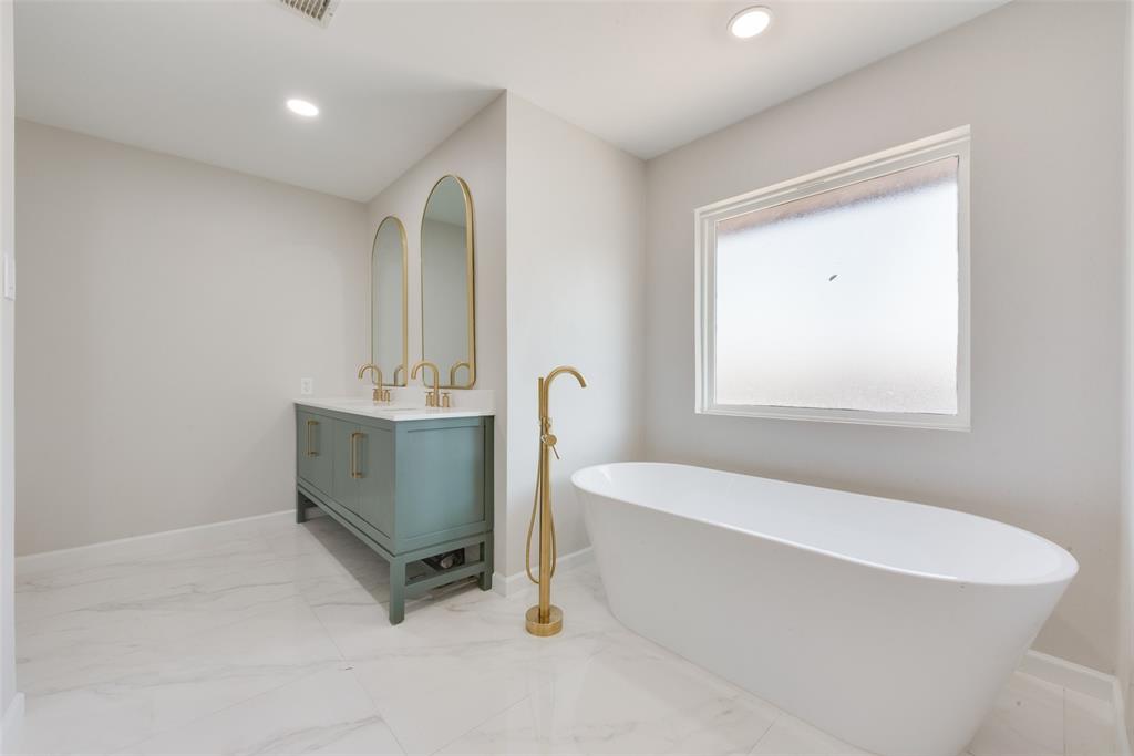 1614 Caddys Circle Garland, TX 75043 - Photo 6 of 13 a bathroom with a sink a bathtub and a window