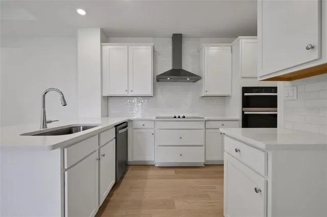 a kitchen with white cabinets and sink