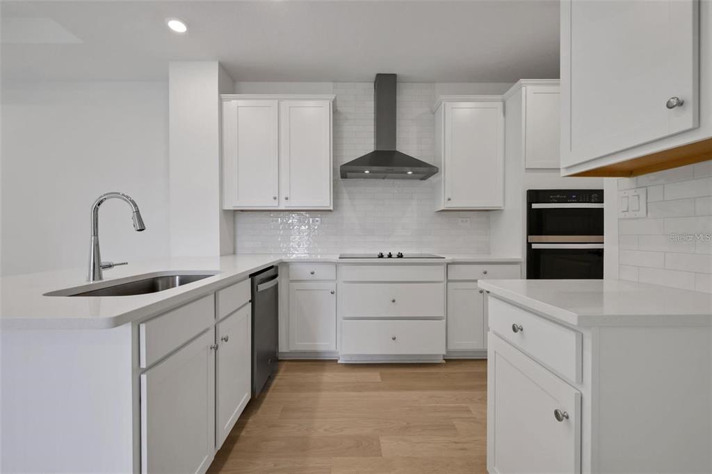 231 Misty Harbor Trace Palm Coast, FL 32137 - Photo 2 of 16 a kitchen with white cabinets and sink