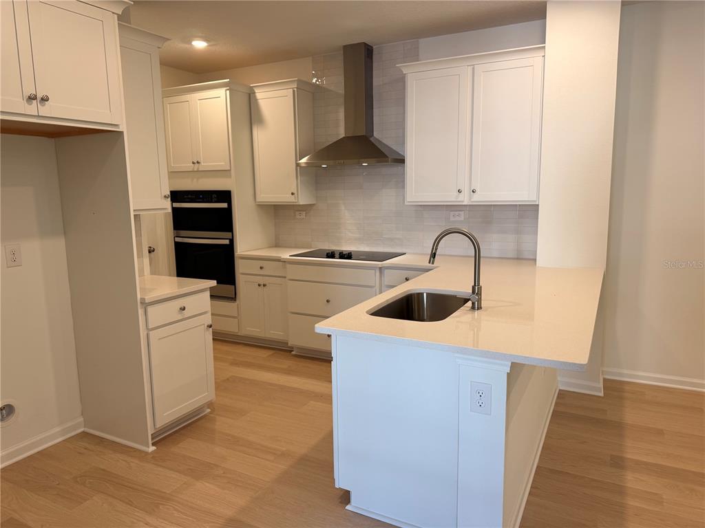 231 Misty Harbor Trace Palm Coast, FL 32137 - Photo 5 of 16 a kitchen with stainless steel appliances granite countertop a sink stove and refrigerator