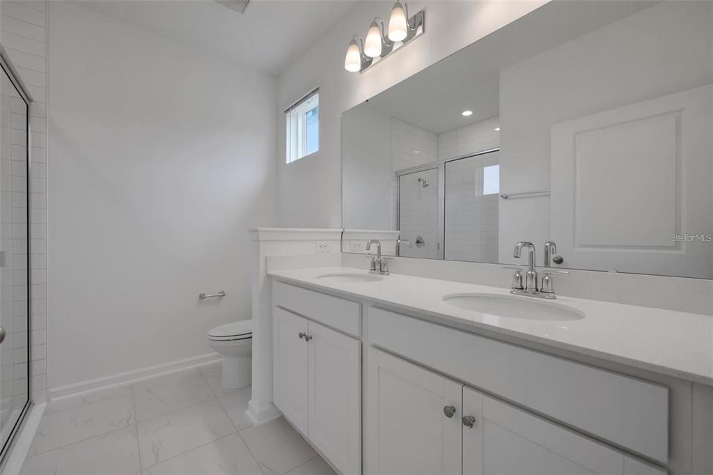 231 Misty Harbor Trace Palm Coast, FL 32137 - Photo 9 of 16 a bathroom with a sink a toilet and a mirror