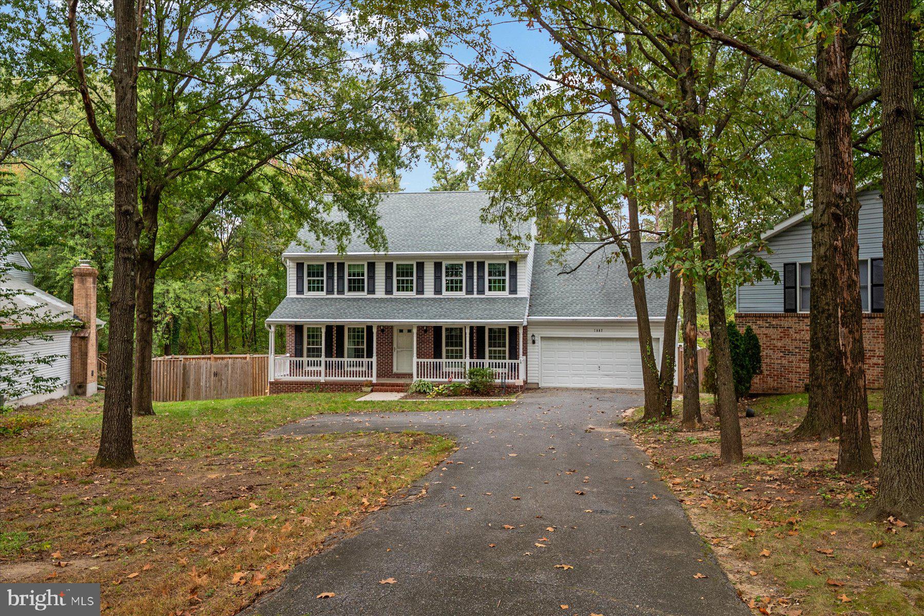 a view of a house with a large tree and a yard
