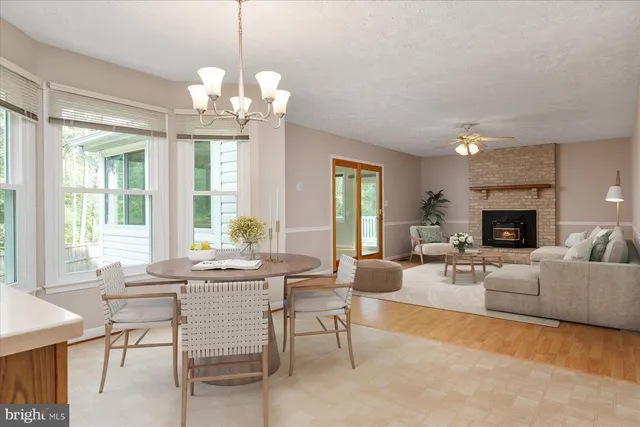 a living room with fireplace furniture and a large window