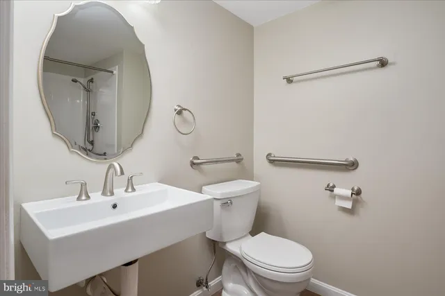 a bathroom with a toilet a sink and mirror