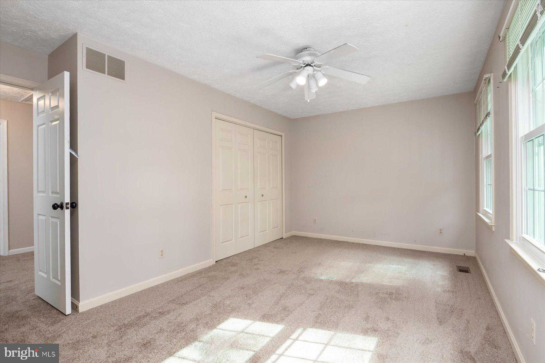 7907 Poplar Grove Road Severn, MD 21144 - Photo 23 of 38 an empty room with chandelier fan and windows