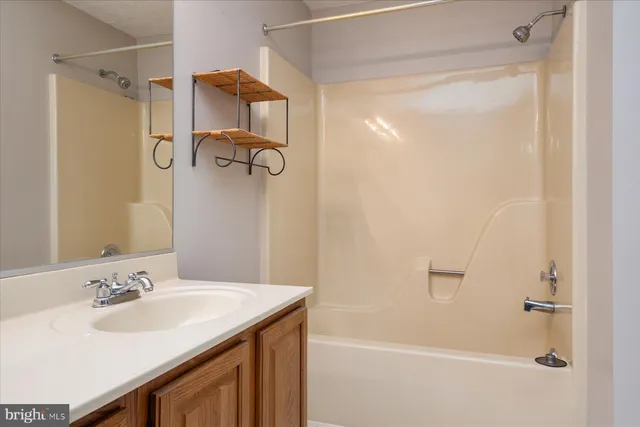 a bathroom with a shower sink vanity and mirror