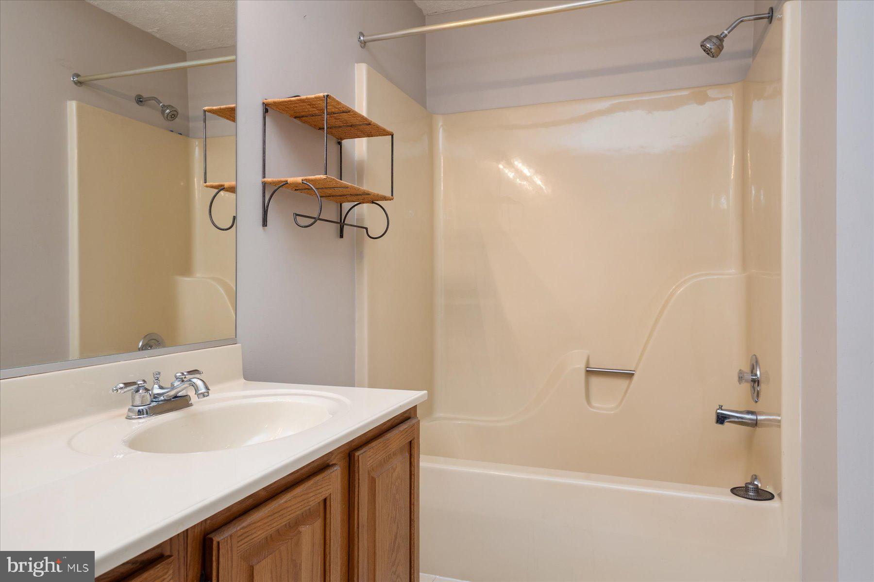 7907 Poplar Grove Road Severn, MD 21144 - Photo 29 of 38 a bathroom with a shower sink vanity and mirror