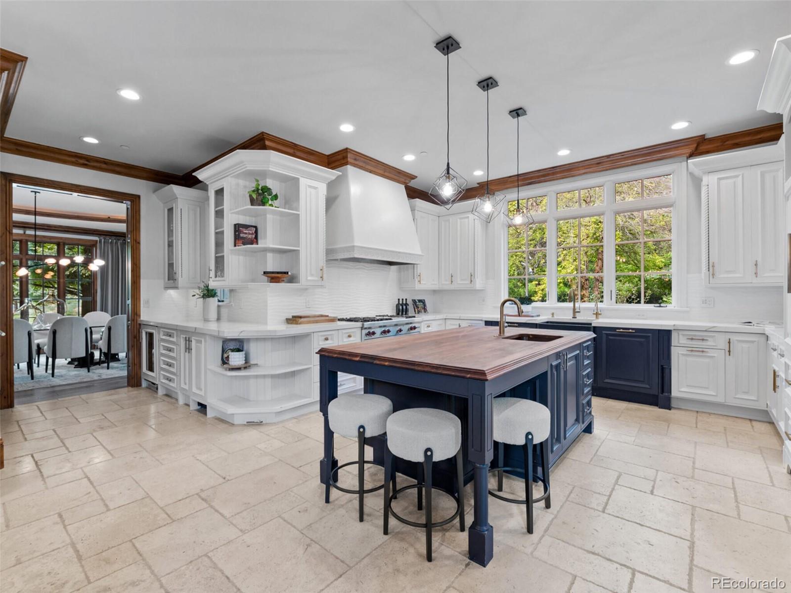 4 Haystack Row Cherry Hills Village, CO 80113 - Photo 15 of 31 a kitchen with kitchen island granite countertop a sink a stove a dining table and chairs