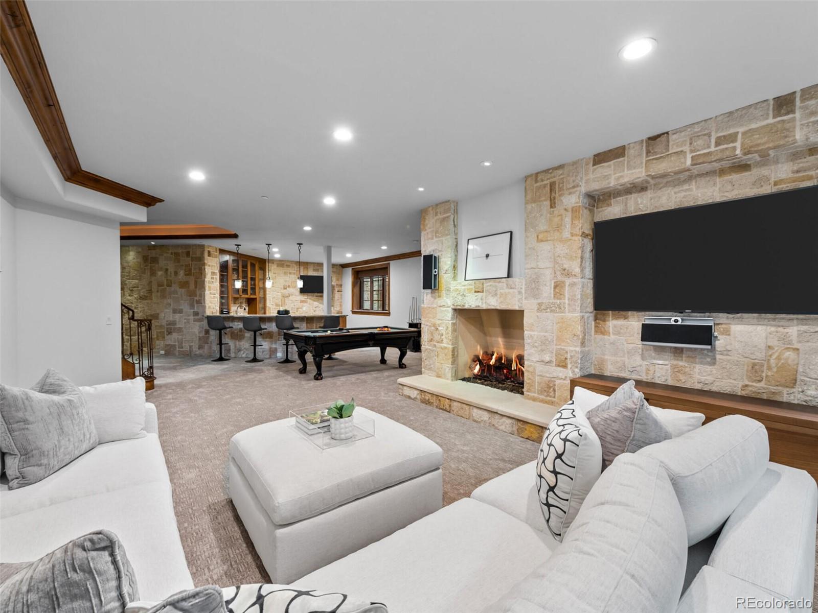 4 Haystack Row Cherry Hills Village, CO 80113 - Photo 28 of 31 a living room with furniture a fireplace and a flat screen tv