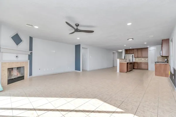 a view of an empty room with a fireplace and a window