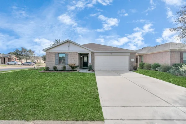 a front view of a house with a yard and trees