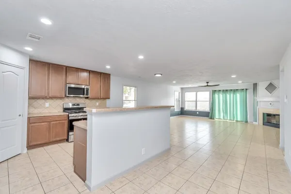 a large kitchen with stainless steel appliances granite countertop a sink and cabinets
