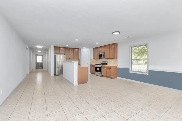 a view of an empty room with a fireplace and a window