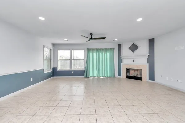 a view of an empty room with a fireplace and a large window