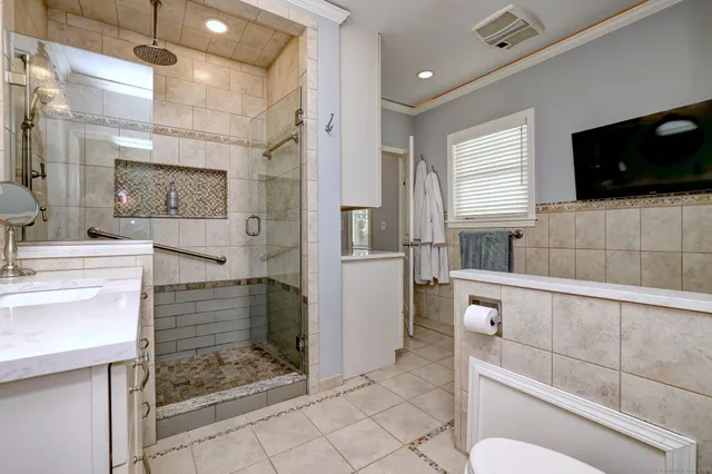 a bathroom with a sink a toilet a mirror and shower
