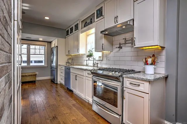 a kitchen with a stove and a wooden floor