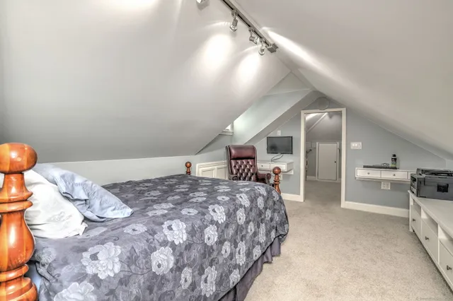 a bedroom with a large bed and a chandelier