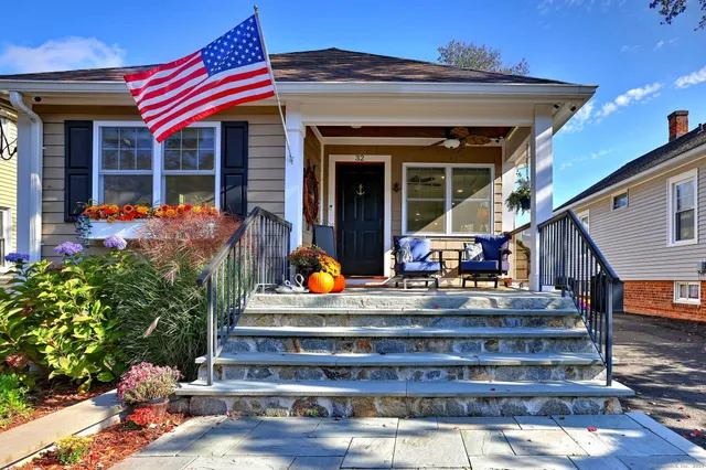 a view of house with wooden deck and furniture